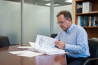 Manager qualité en lecture d'un guide ISO dans un bureau moderne
