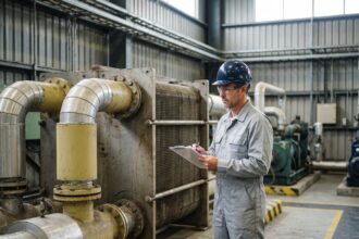 Ingénieur industriel inspectant un échangeur thermique dans une usine, illustrant les échanges thermiques industriels