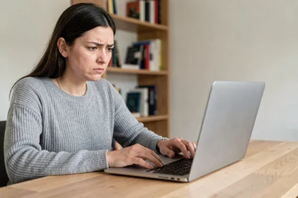 Femme frustrée face à un problème de connexion sur son compte Arkevia depuis un ordinateur portable à domicile